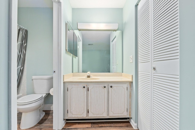 bathroom featuring wood-type flooring, vanity, and toilet