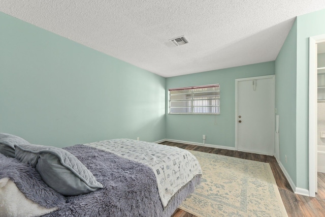 bedroom with wood-type flooring and a textured ceiling