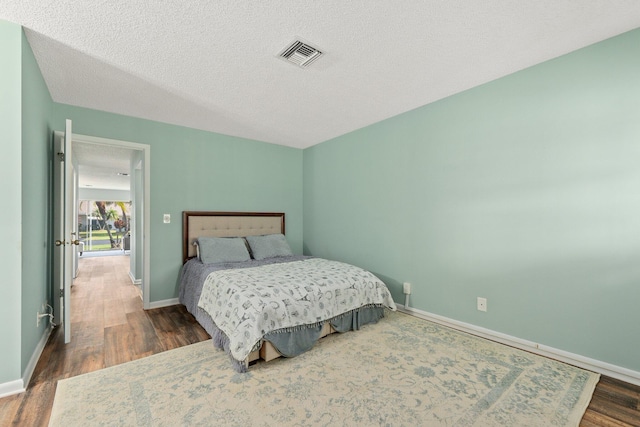 bedroom featuring a textured ceiling and dark wood-type flooring