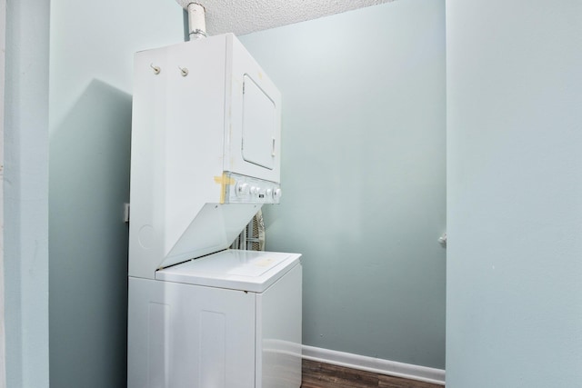 laundry room with stacked washer and dryer, dark hardwood / wood-style floors, and a textured ceiling