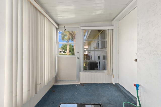 unfurnished sunroom with cooling unit, lofted ceiling, and wood ceiling