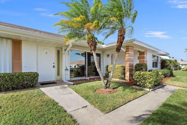 view of exterior entry with a yard