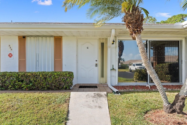 view of exterior entry with a yard