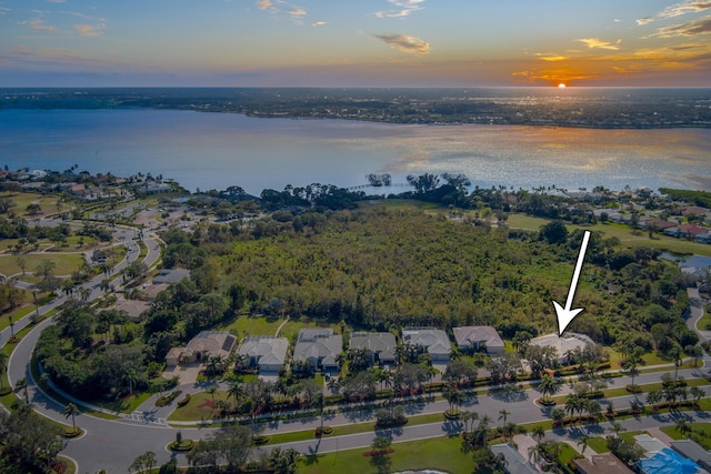 aerial view at dusk featuring a water view