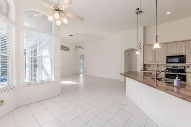 kitchen featuring tasteful backsplash, ceiling fan, sink, electric stove, and pendant lighting