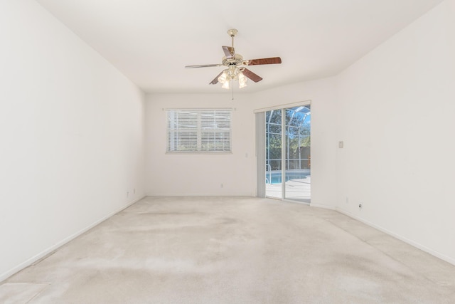 spare room with ceiling fan and light carpet