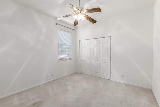 unfurnished bedroom featuring ceiling fan, a closet, and light carpet