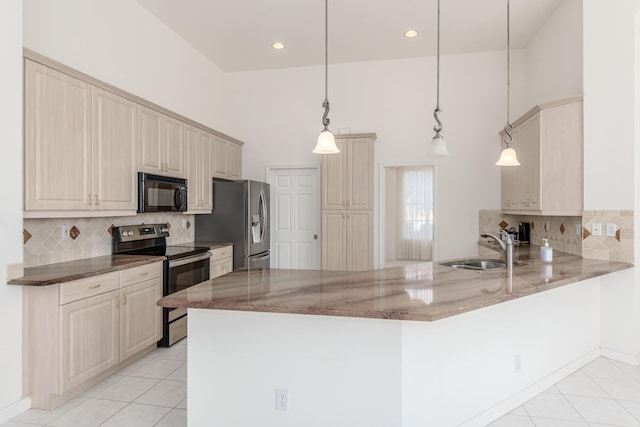 kitchen featuring pendant lighting, kitchen peninsula, sink, and appliances with stainless steel finishes