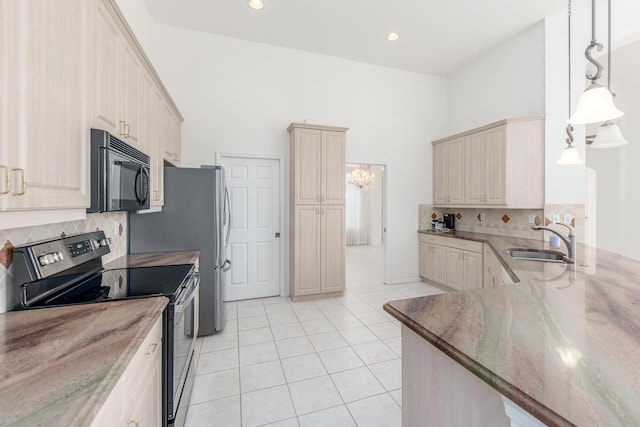 kitchen featuring pendant lighting, black appliances, sink, decorative backsplash, and light tile patterned floors