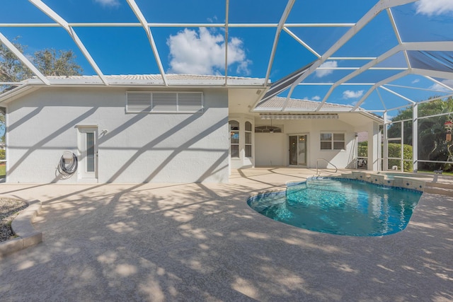 view of swimming pool featuring ceiling fan, a lanai, and a patio