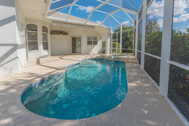 view of pool featuring an in ground hot tub, glass enclosure, ceiling fan, and a patio area