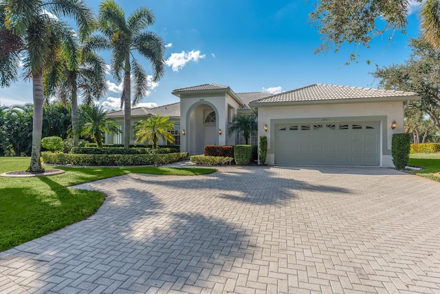 mediterranean / spanish house with a garage and a front yard