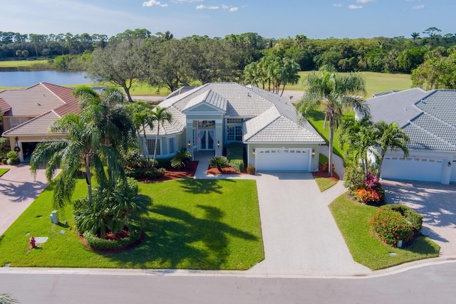 view of front facade featuring a front yard, a water view, and a garage