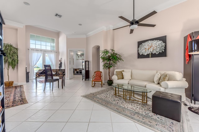 living room with a high ceiling, light tile patterned floors, ceiling fan, and crown molding