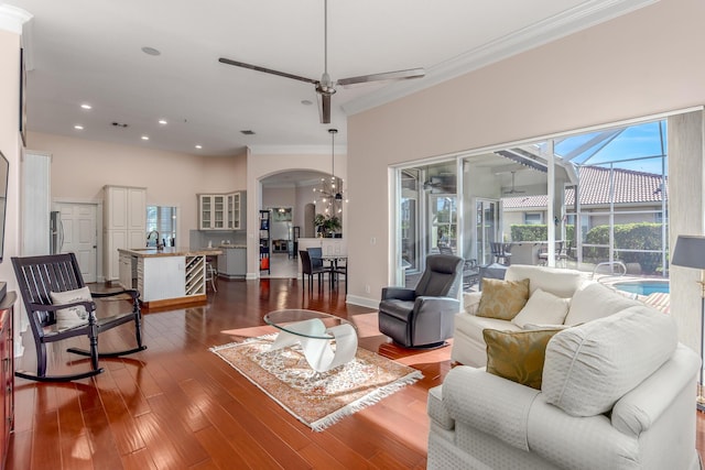 living room with crown molding, sink, ceiling fan, and wood-type flooring