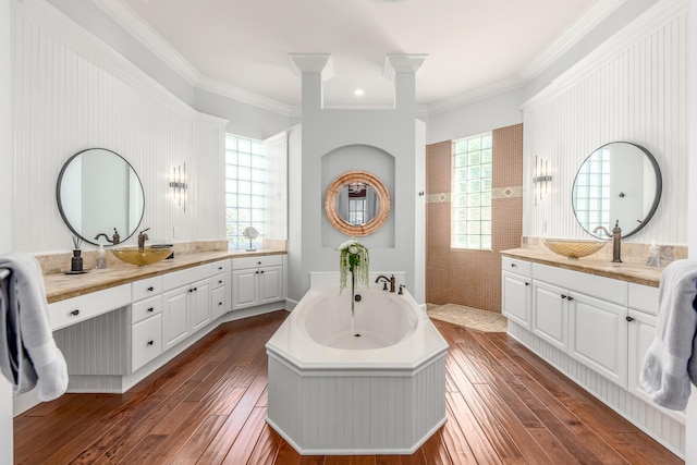 bathroom featuring a tub to relax in, vanity, ornamental molding, and hardwood / wood-style flooring