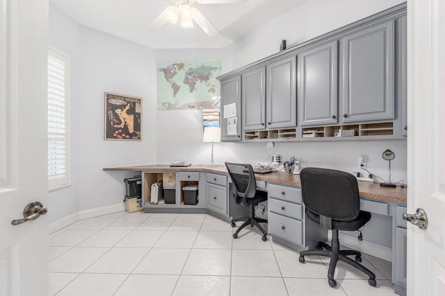 office area with ceiling fan, plenty of natural light, light tile patterned floors, and built in desk