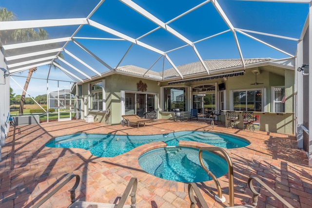 view of swimming pool featuring a lanai, a patio area, an in ground hot tub, and ceiling fan