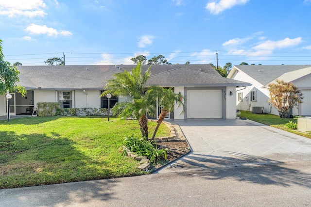 single story home featuring cooling unit, a front yard, and a garage