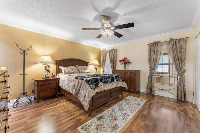 bedroom with hardwood / wood-style flooring, ceiling fan, ornamental molding, and a textured ceiling