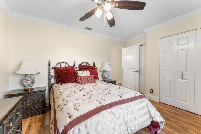 bedroom featuring a textured ceiling, light hardwood / wood-style floors, ceiling fan, and ornamental molding