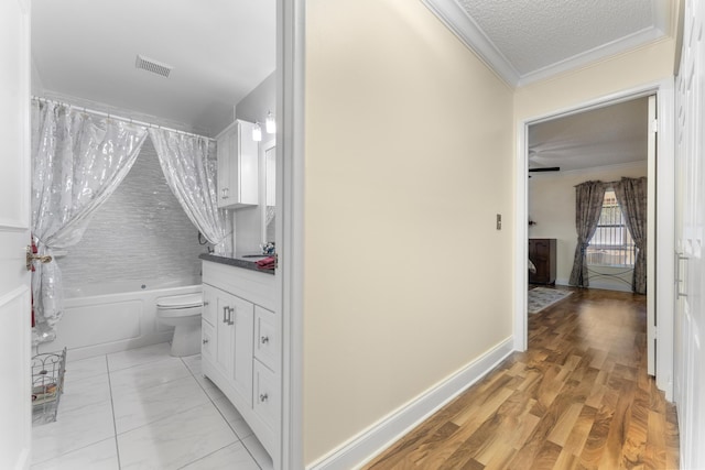 full bathroom featuring vanity, shower / bath combination with curtain, hardwood / wood-style flooring, toilet, and a textured ceiling