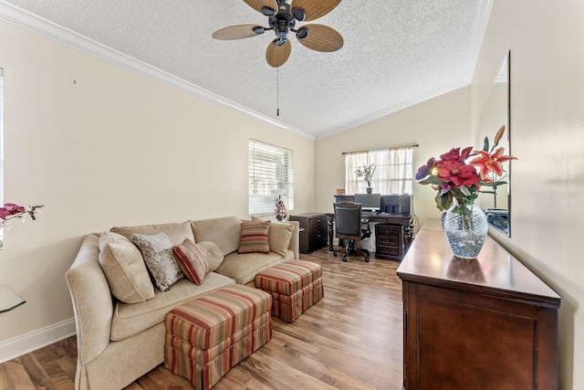 living room featuring lofted ceiling, ceiling fan, ornamental molding, light wood-type flooring, and a textured ceiling