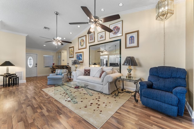 living room featuring hardwood / wood-style floors, vaulted ceiling, and ornamental molding