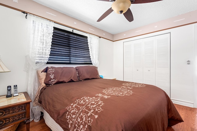 bedroom with hardwood / wood-style floors, ceiling fan, a textured ceiling, and a closet