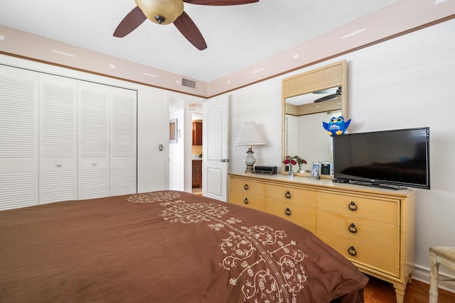 bedroom with ceiling fan, a closet, and dark wood-type flooring