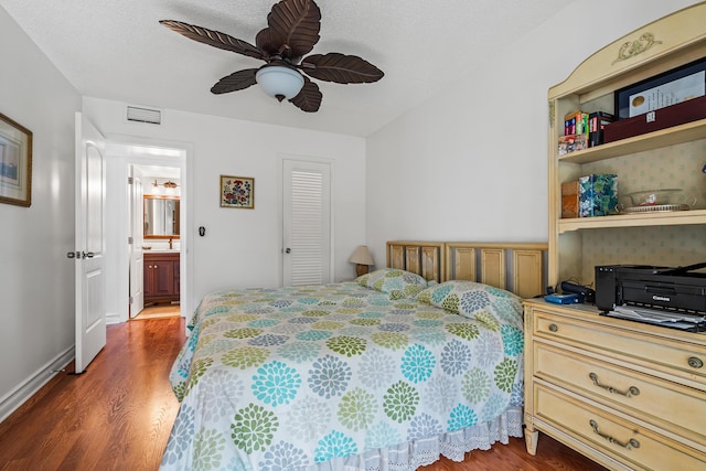 bedroom with ensuite bath, ceiling fan, dark hardwood / wood-style floors, a textured ceiling, and a closet