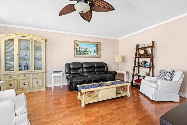 living room with crown molding, ceiling fan, and wood-type flooring