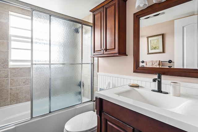 full bathroom with shower / bath combination with glass door, vanity, and toilet