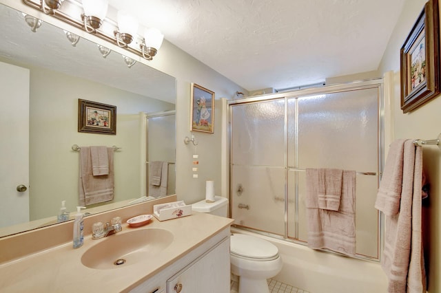 full bathroom featuring vanity, tile patterned floors, toilet, enclosed tub / shower combo, and a textured ceiling