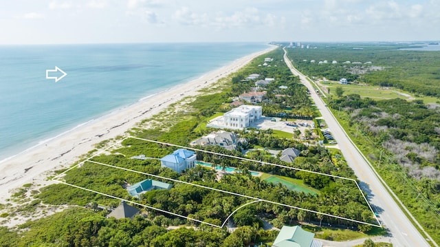 drone / aerial view with a water view and a beach view