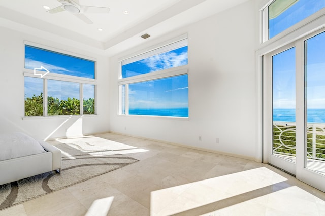 interior space featuring ceiling fan, a water view, and a wealth of natural light