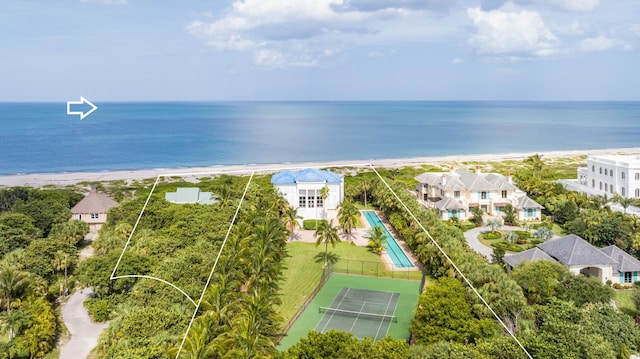 birds eye view of property with a water view and a beach view