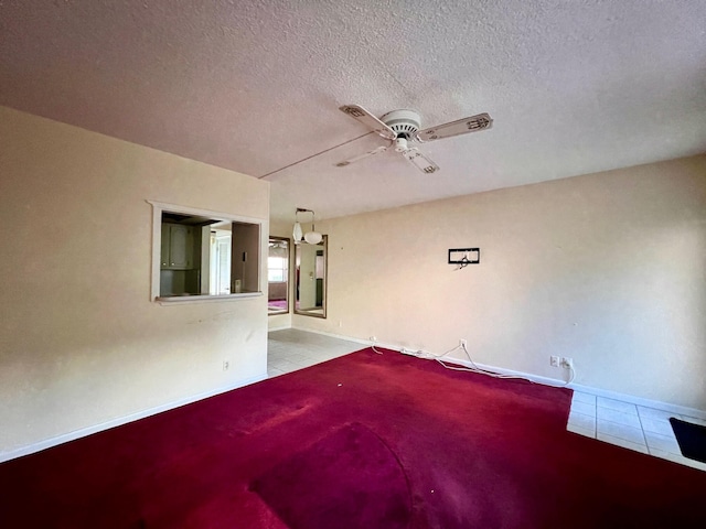 tiled spare room featuring ceiling fan and a textured ceiling