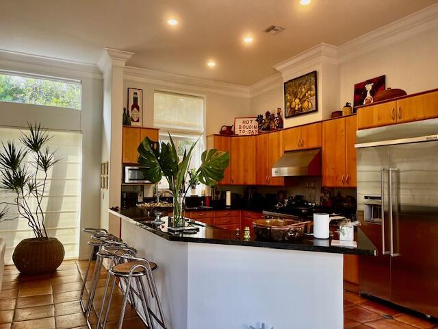 kitchen featuring ornamental molding, backsplash, and appliances with stainless steel finishes