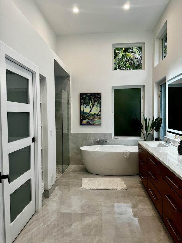 bathroom featuring plus walk in shower and vanity