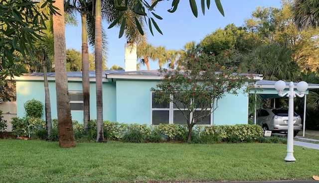 view of property exterior with a yard and a carport