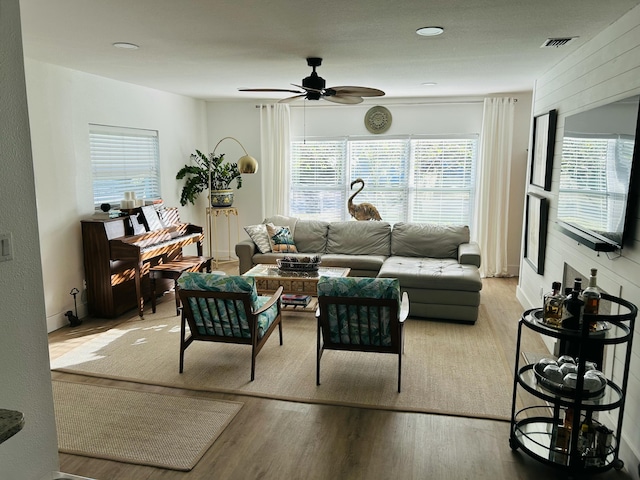 living room with light hardwood / wood-style floors and ceiling fan