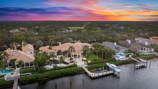 aerial view at dusk featuring a water view