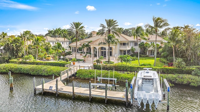 dock area with a yard, a water view, and a balcony