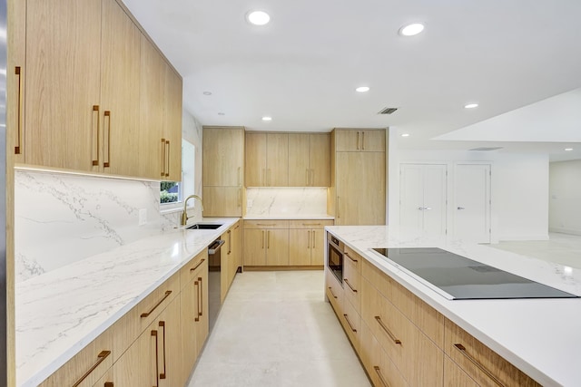 kitchen with sink, light brown cabinets, tasteful backsplash, light stone counters, and appliances with stainless steel finishes