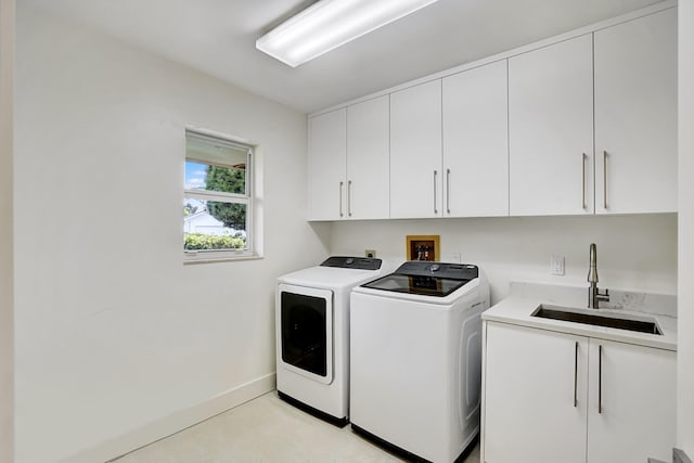 laundry room with cabinets, independent washer and dryer, and sink