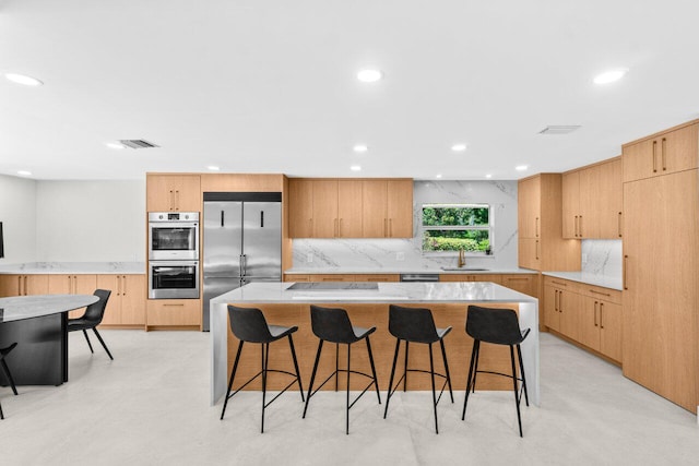 4246 Live Oak Blvd, Delray Beach, FL 33445 - kitchen featuring stainless steel appliances, a breakfast bar, a sink, decorative backsplash, and recessed lighting
