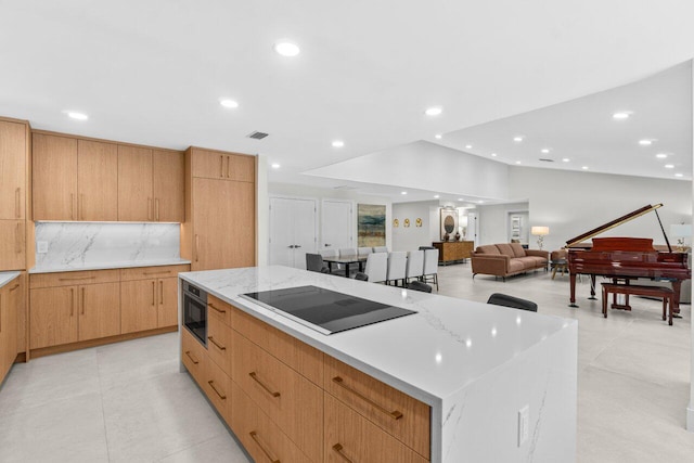 4246 Live Oak Blvd, Delray Beach, FL 33445 - kitchen with black electric stovetop, a large island, modern cabinets, recessed lighting, and light stone countertops