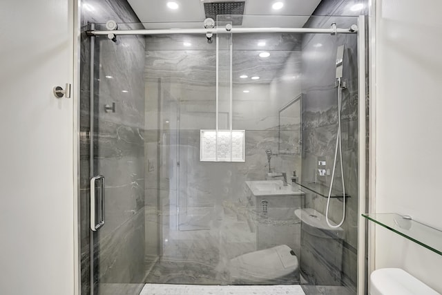 bathroom featuring a shower with door and toilet