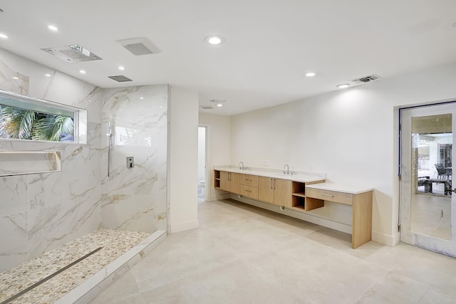 bathroom with vanity and tiled shower